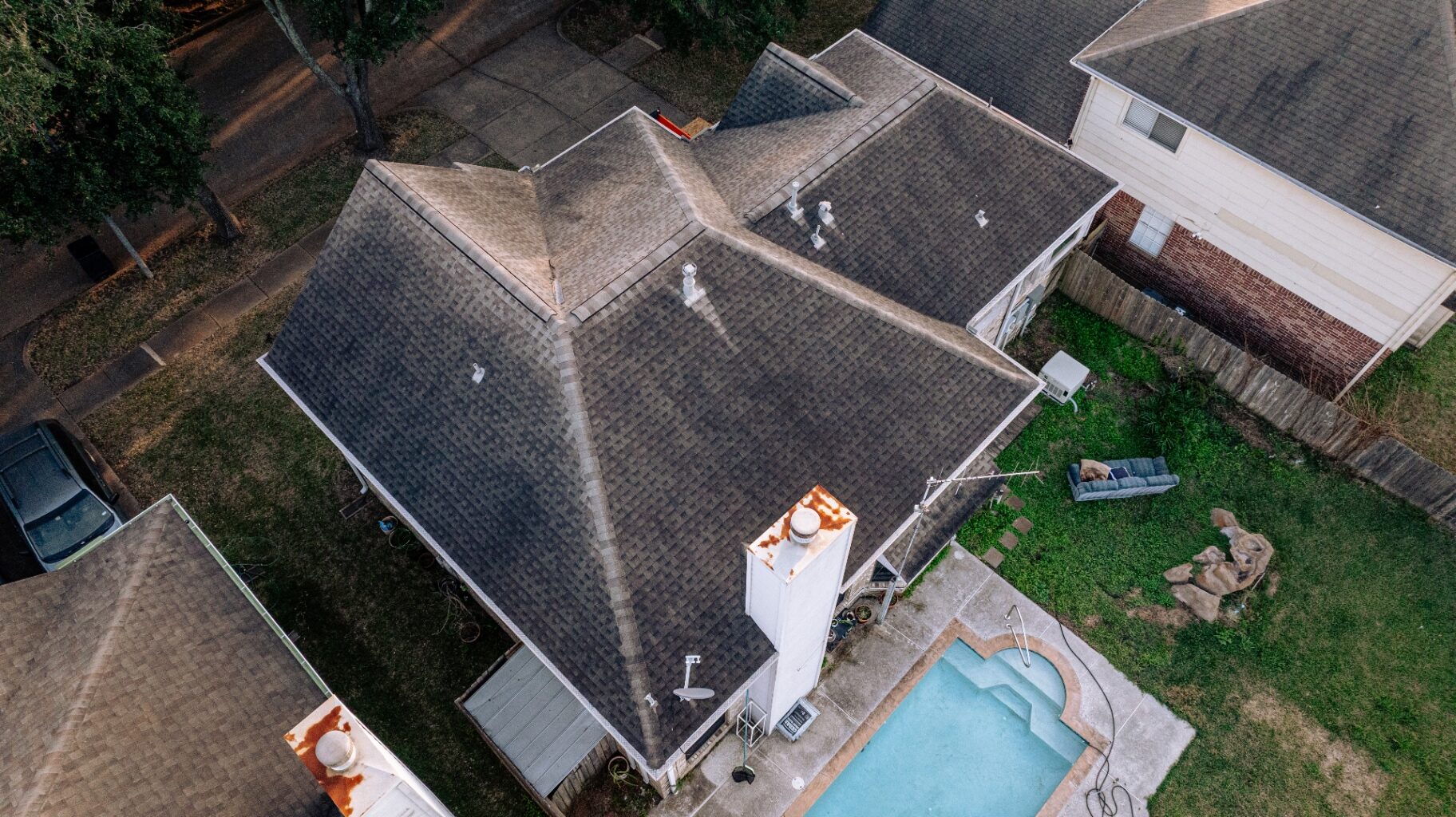 Aerial view of the worn, sun-faded asphalt shingle roof at 6411 Drake Elm Dr in Houston before replacement