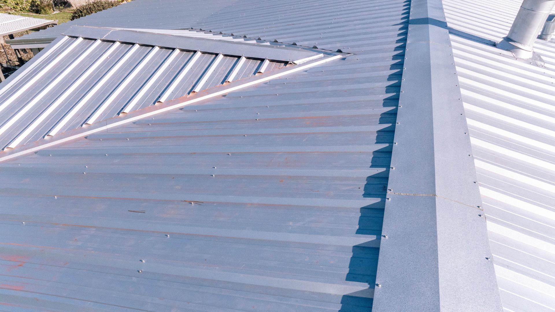 Silver standing seam metal roof panels and ridge detail on a completed Houston area roofing project